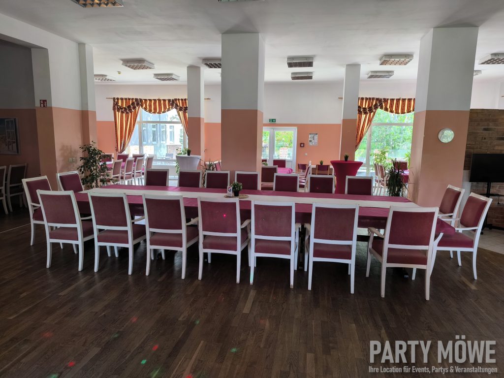 Saal mit langer Tafel und Stehtischen