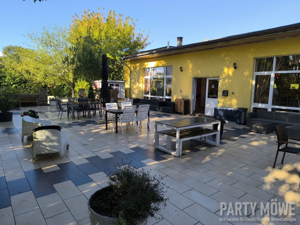Terrasse im Abendlicht mit Sitzgruppen und Grill